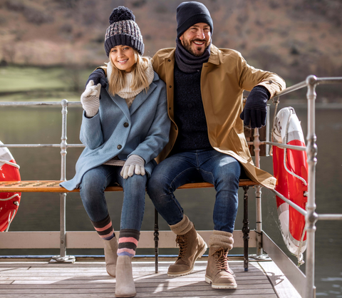 man and woman sat on bench wearing heat holders products